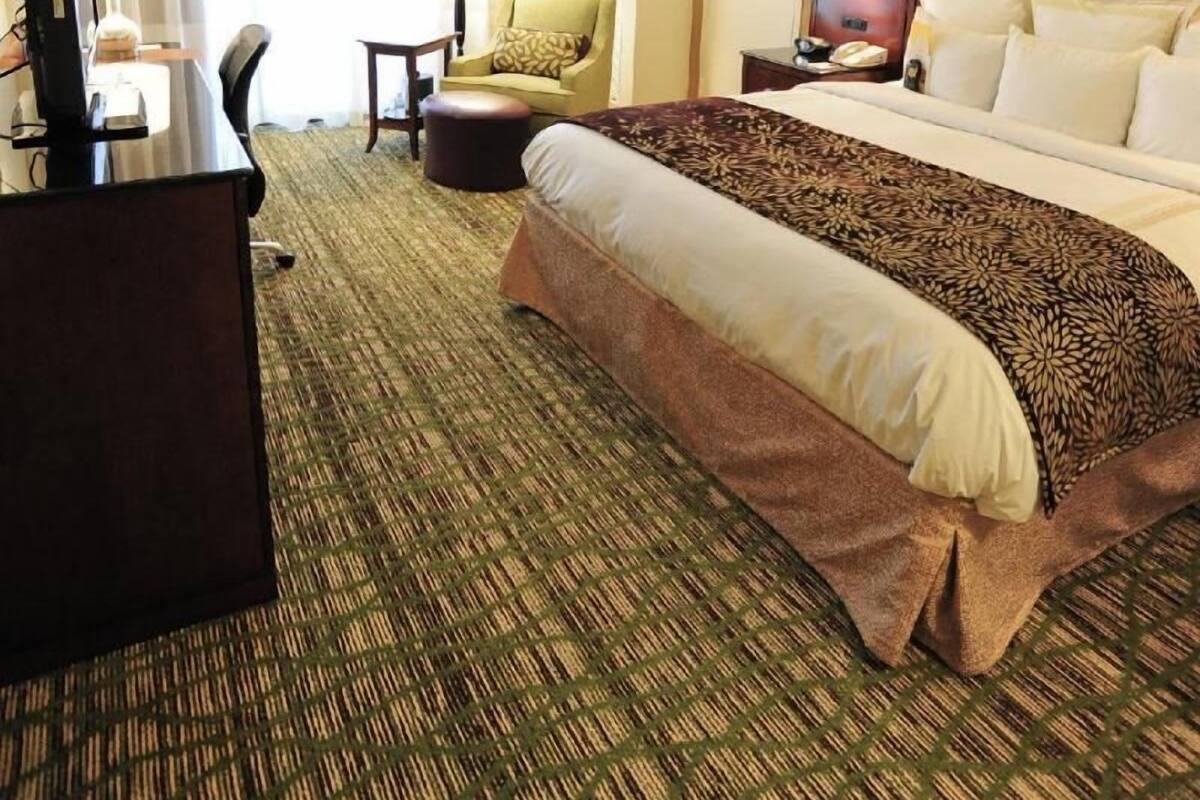 Une chambre d’hôtel équipée d’un lit, d’un bureau, d’une chaise et d’un téléviseur.