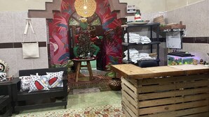 Una habitación con un árbol de Navidad, un banco de madera, piso de baldosas y un estante con ropa doblada.