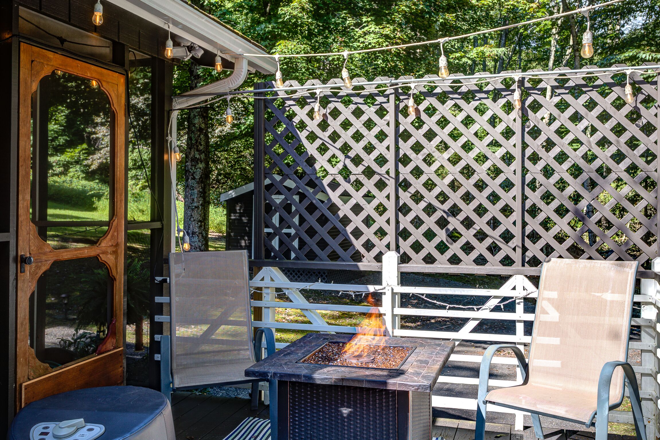An outdoor seating area with a fire feature, a wooden door, and a lattice fence.