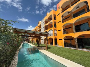 Ein mehrstöckiges Hotel mit Swimmingpool, Außenbereich und Balkonen.