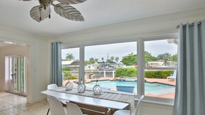 Ein Essbereich mit Blick auf einen Pool und eine Terrasse.