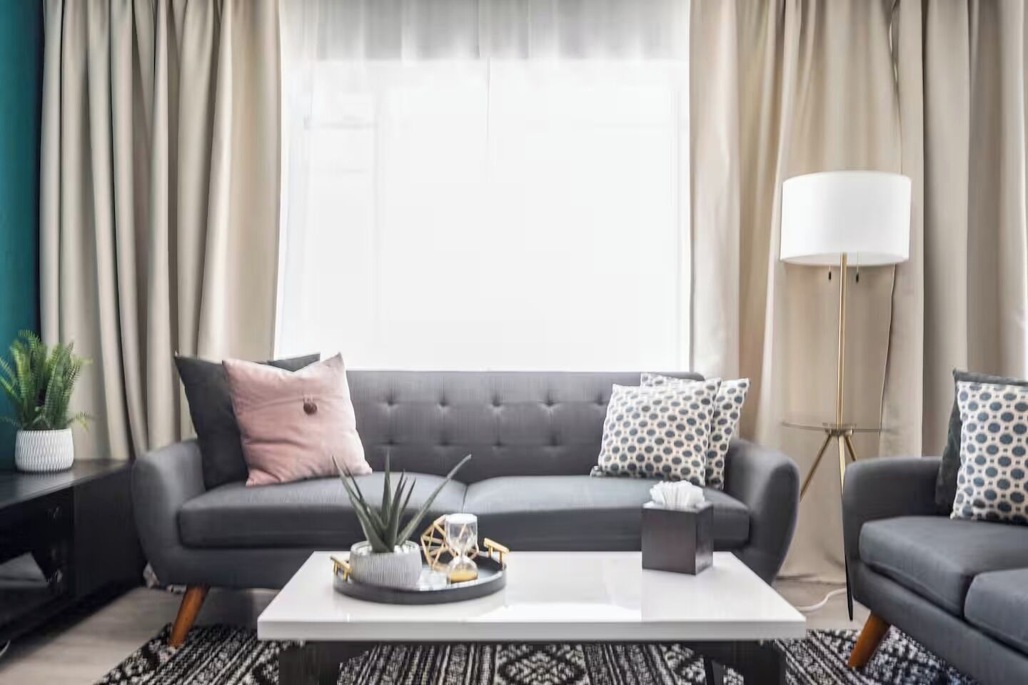 A modern living room with a grey sofa, a white coffee table, and a floor lamp.