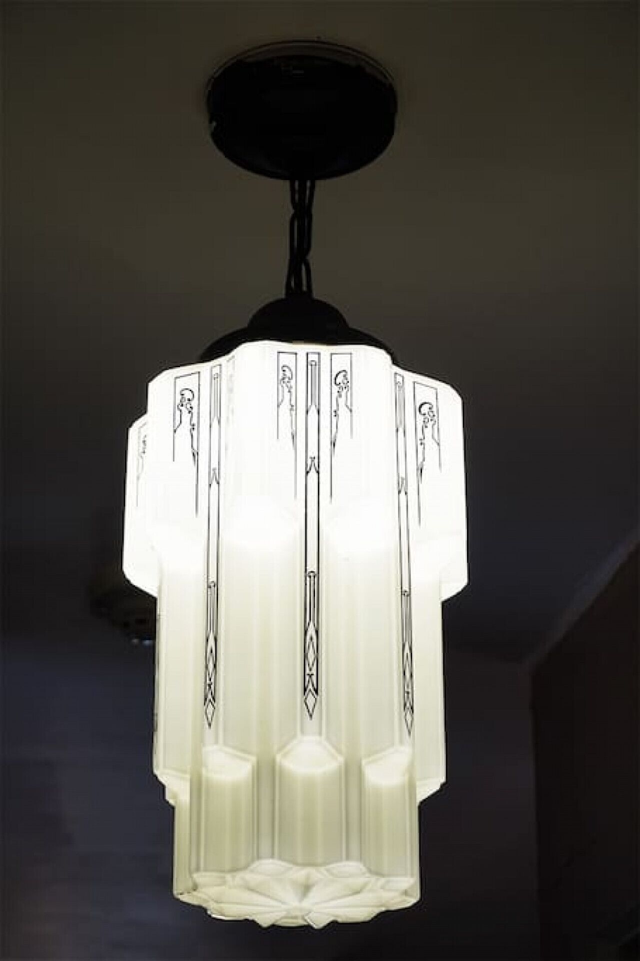 Un lustre doté d’un abat-jour blanc et de motifs géométriques.