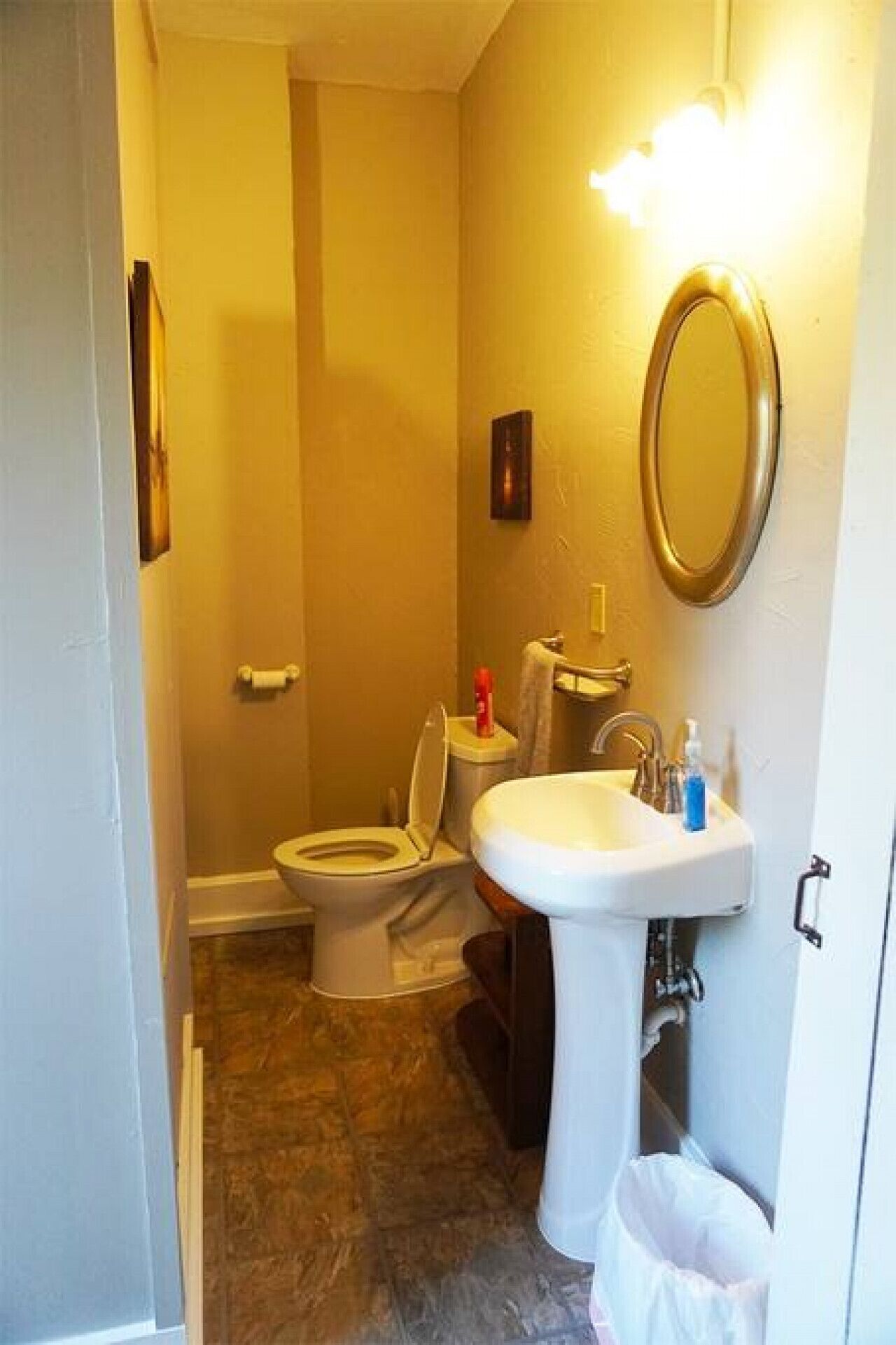 Ein kleines Badezimmer mit Toilette, Waschbecken und Spiegel.