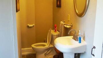 Ein kleines Badezimmer mit Toilette, Waschbecken und Spiegel.