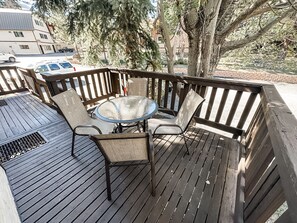A wooden deck with a round glass table and four chairs. - Alpine Adventure Haven- Walk to Village Gondola, Biking &Trails BTC 10013 (Mammoth Lakes)