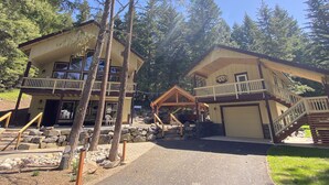 A lodge with a two-story structure, a covered outdoor seating area, and a stone-paved entrance. - Kid Friendly Cabin with Mother-in-law Suite and Hot Tub! (Ronald)