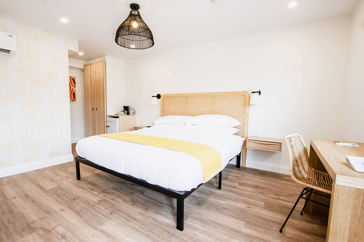Een moderne slaapkamer met een houten bed, een bureau en een stoel.
