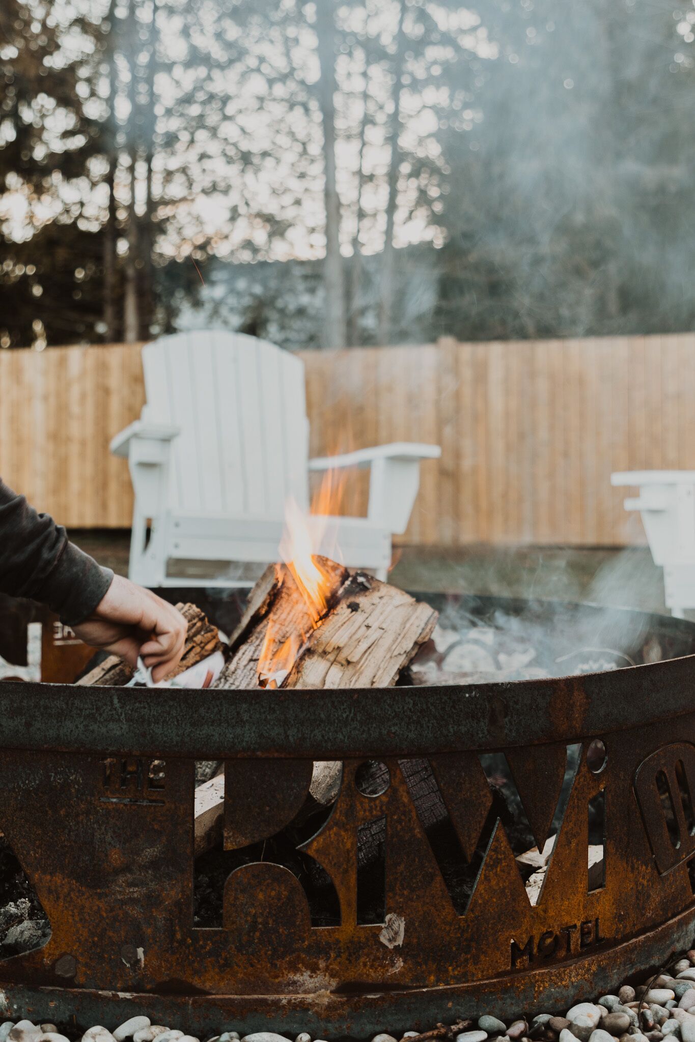 A rustic fire pit with the text "The River Motel" on a metal structure.