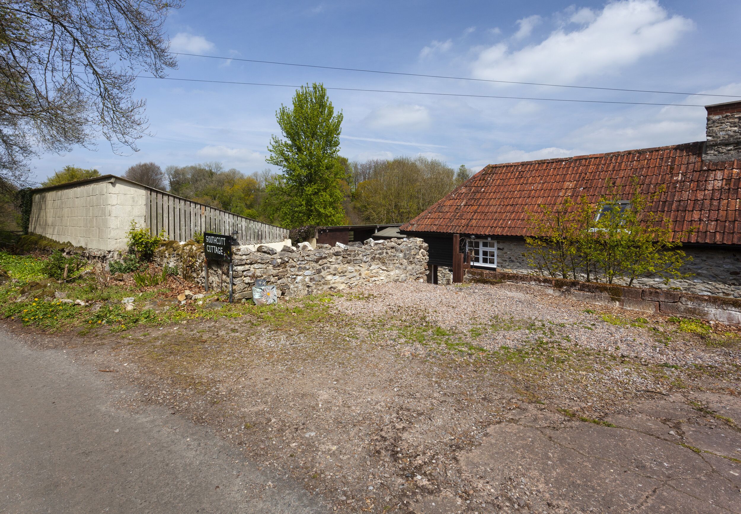 A rustic building with a stone foundation and a red-tiled roof.