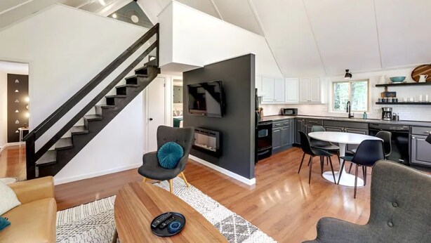 Ein modernes Interieur mit Treppe, Kamin, Essbereich und Küche.