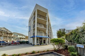 A multi-story hotel with a flat facade, balconies, and a blue awning.