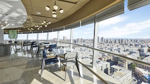 A modern office space with a curved ceiling, large windows offering a city view, and contemporary furniture. - Hilton Garden Inn Anshan Haicheng (Anshan)