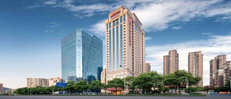Un edificio moderno de gran altura, con fachada de vidrio y diseño tradicional en la otra cara.