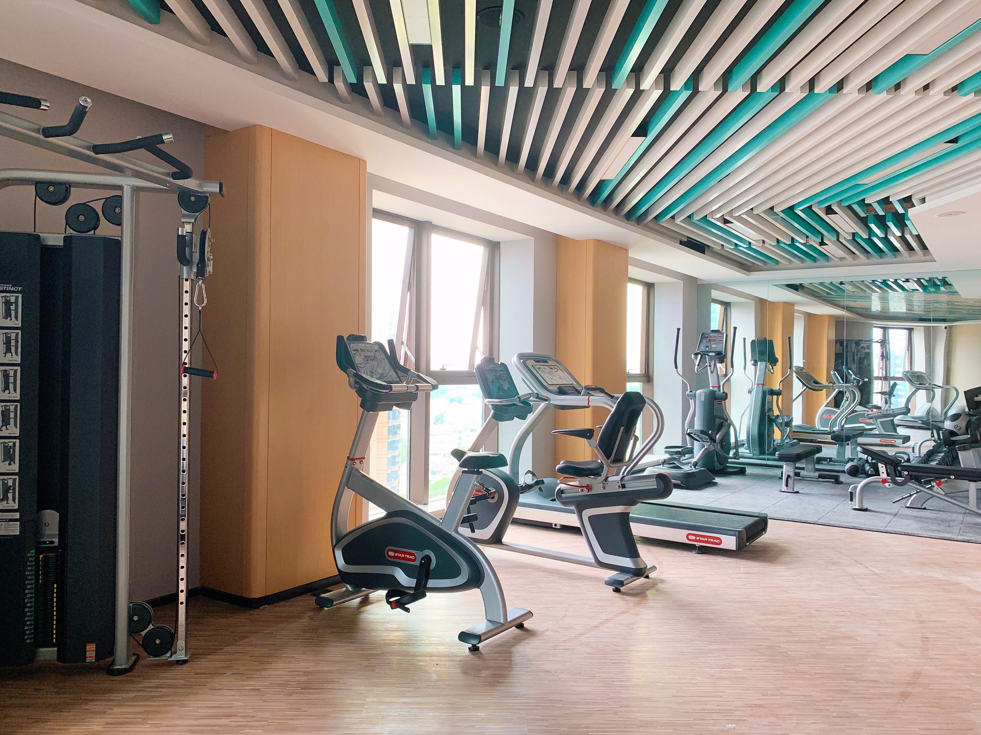 A gym with treadmills, elliptical machines, and weightlifting equipment.