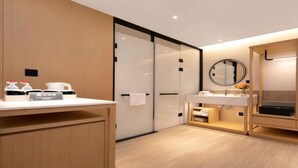 A modern bathroom with a wooden vanity, a mirror, and a sink. There is a towel rack and a small shelf with toiletries. - Hilton Garden Inn Changsha Yuelu (Changsha)