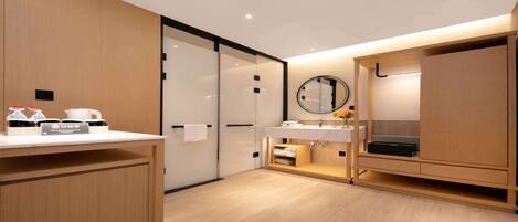 A modern bathroom with a wooden vanity, a mirror, and a sink. There is a towel rack and a small shelf with toiletries.