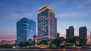 A high-rise hotel with a prominent sign, surrounded by other tall buildings and trees. - Hilton Garden Inn Changsha Yuelu (Changsha)