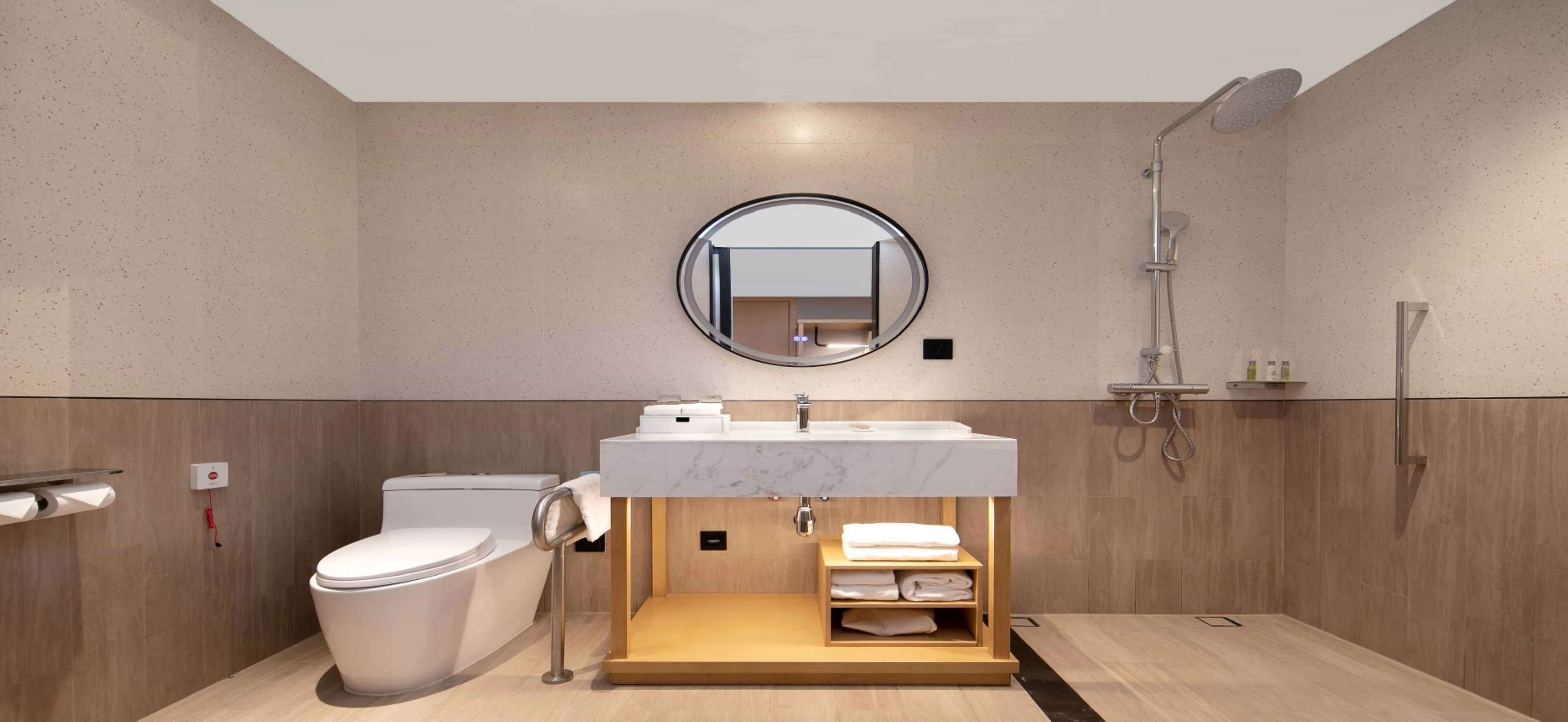 A modern bathroom with a toilet, sink, and shower.