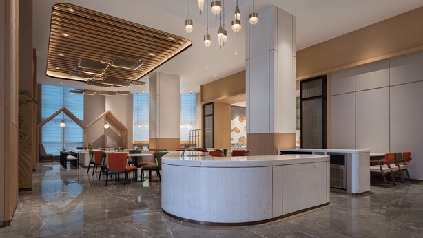 A modern hotel lobby with a central reception desk, seating areas, and a high ceiling with pendant lighting. - Hilton Garden Inn Changsha Yuelu (Changsha)