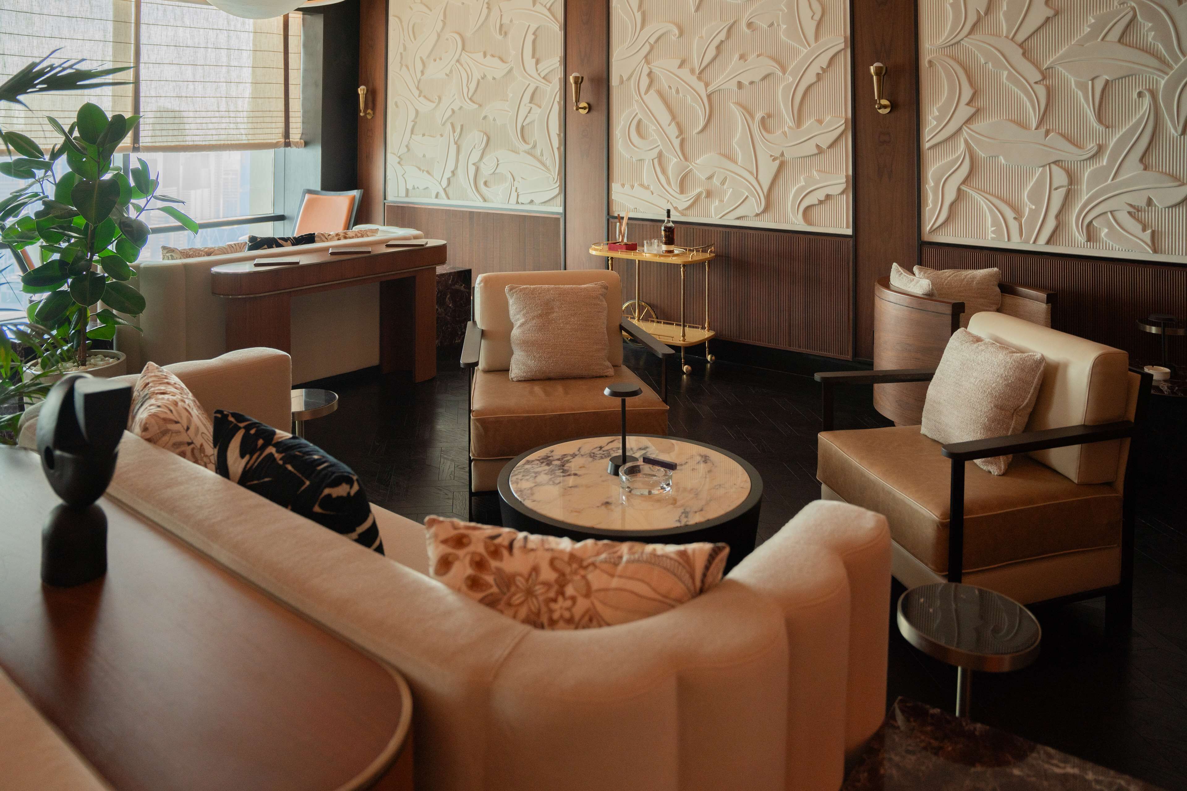 A modern hotel lobby with a reception desk, seating area, and decorative wall panels.