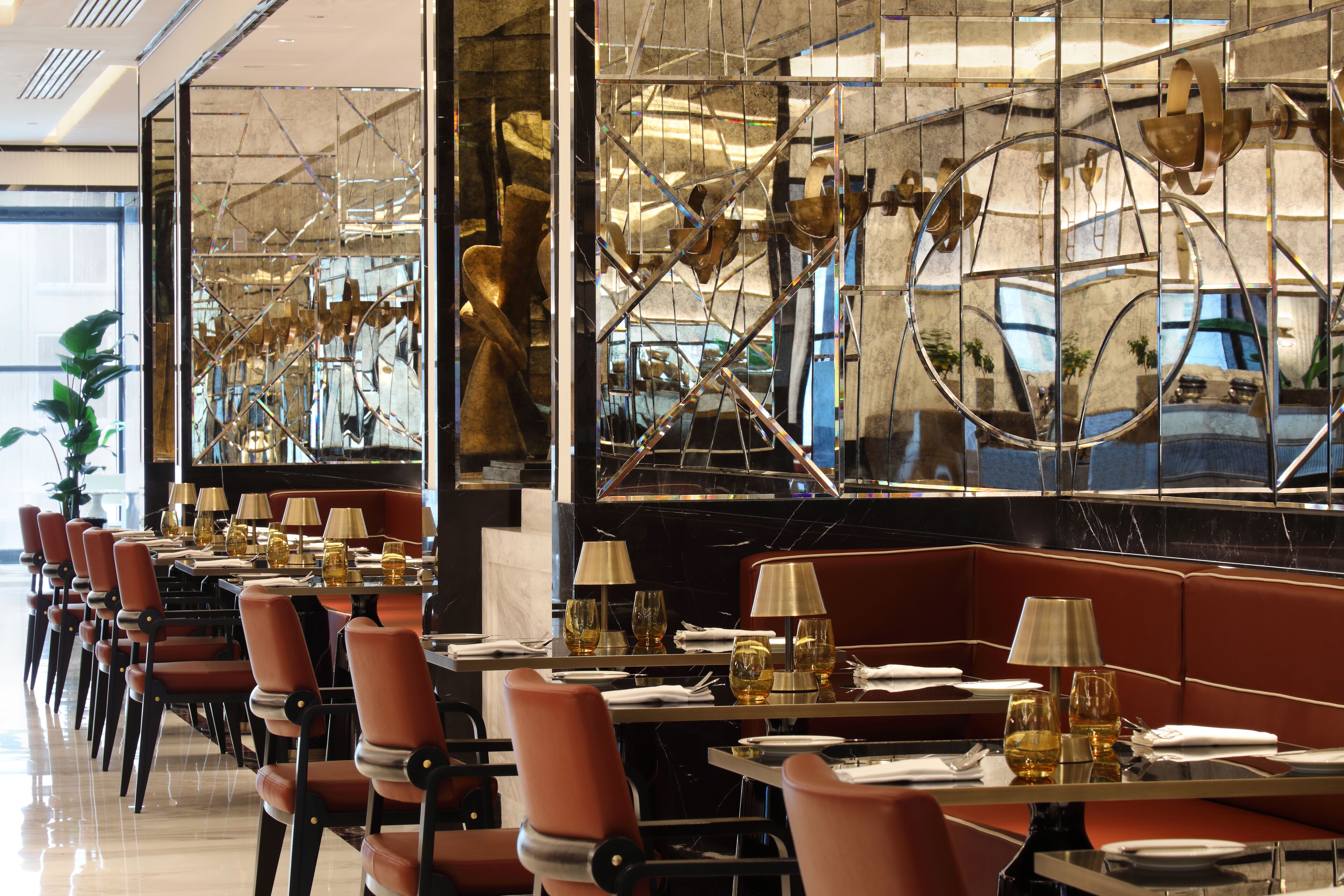 A restaurant with a long table, chairs, and a bar area.