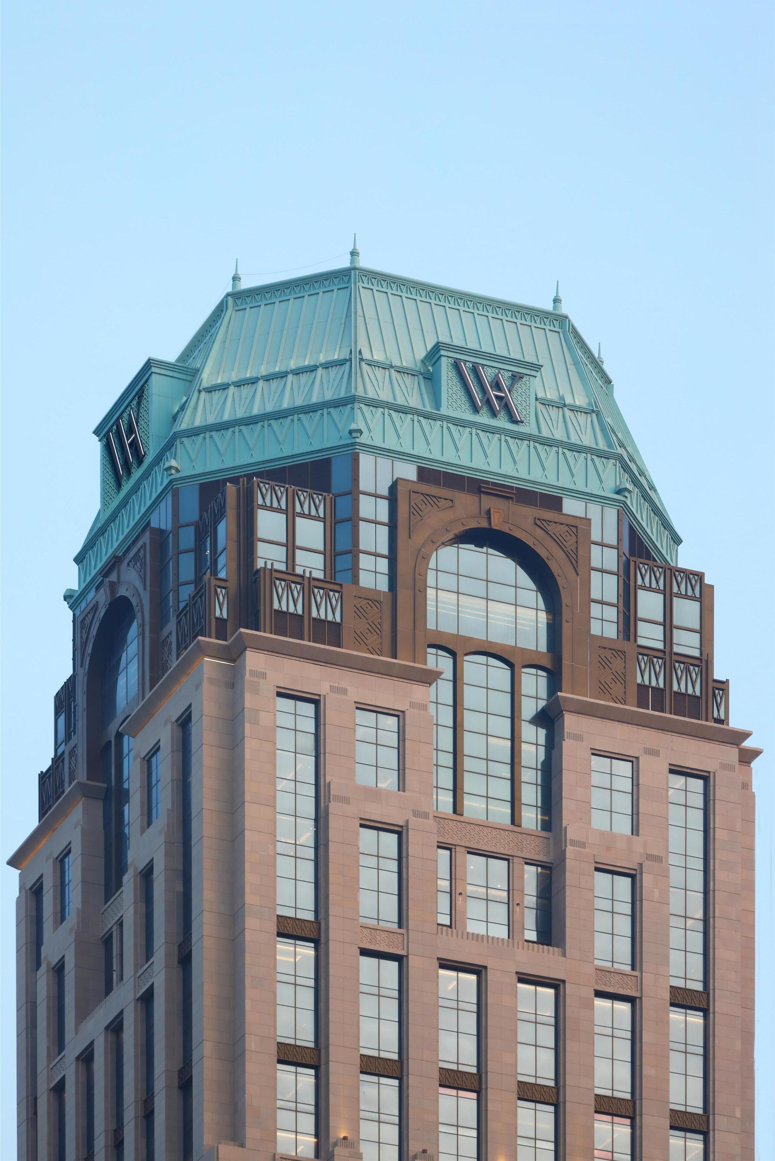 A multi-story building with a prominent arched entrance and a large, octagonal glass roof.