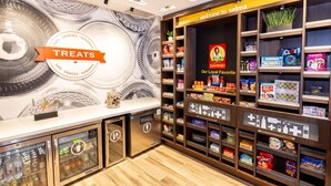 A snack and sundries section with a variety of packaged snacks, a vending machine, and a display of local favorites.