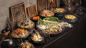 Variedad de platos tradicionales expuestos sobre una mesa, rodeada de separadores de madera y elementos decorativos.