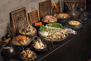 Diverse traditionele gerechten gepresenteerd op een tafel, omgeven door houten scheidingswanden en decoratieve details.