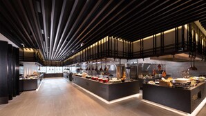 Una cocina moderna con una isla central, iluminación colgante y vista al área de comedor.