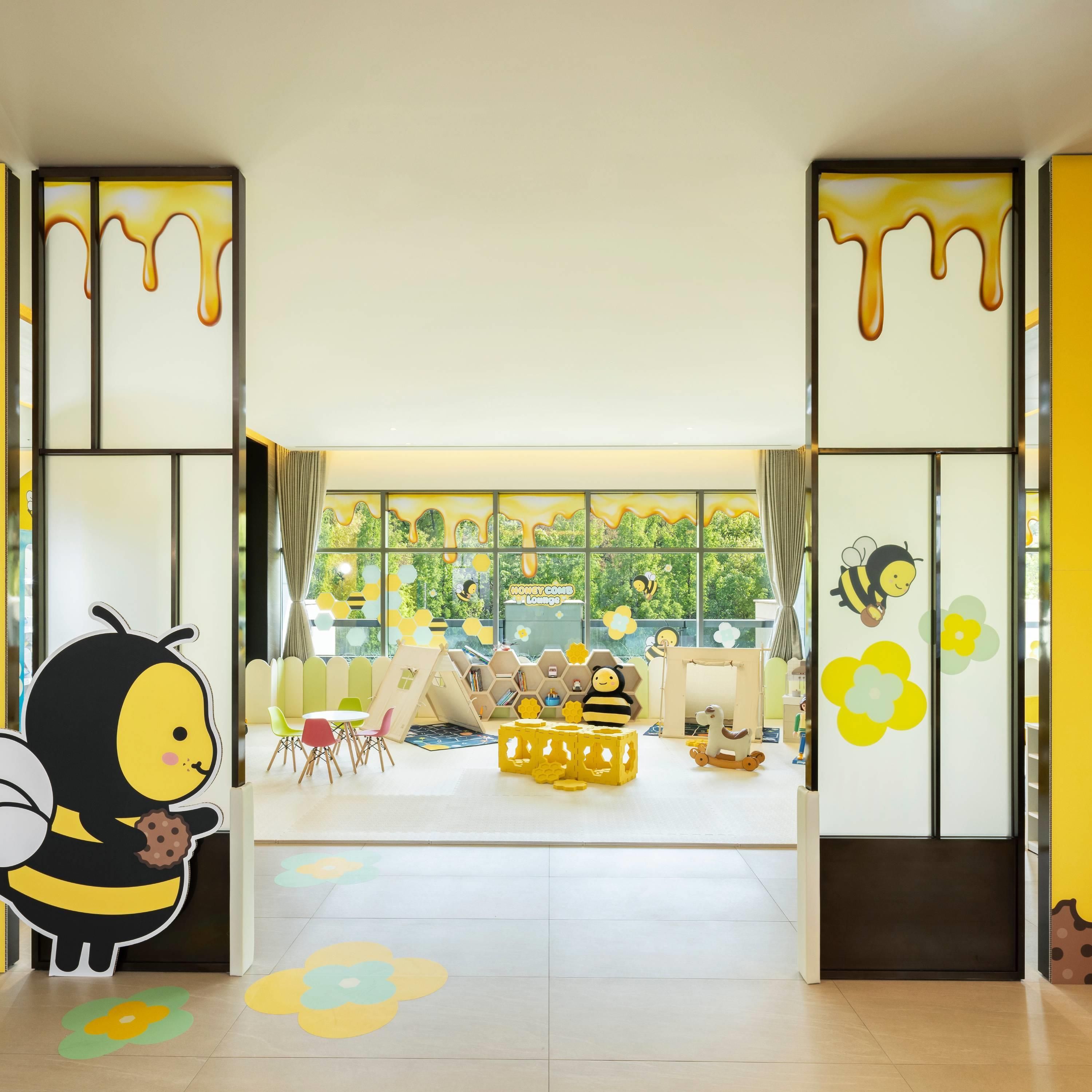 A children's playroom with a large window, colorful play mats, and a bee decoration.