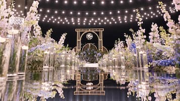 Un suelo reflectante con un arreglo floral central y luces colgantes.