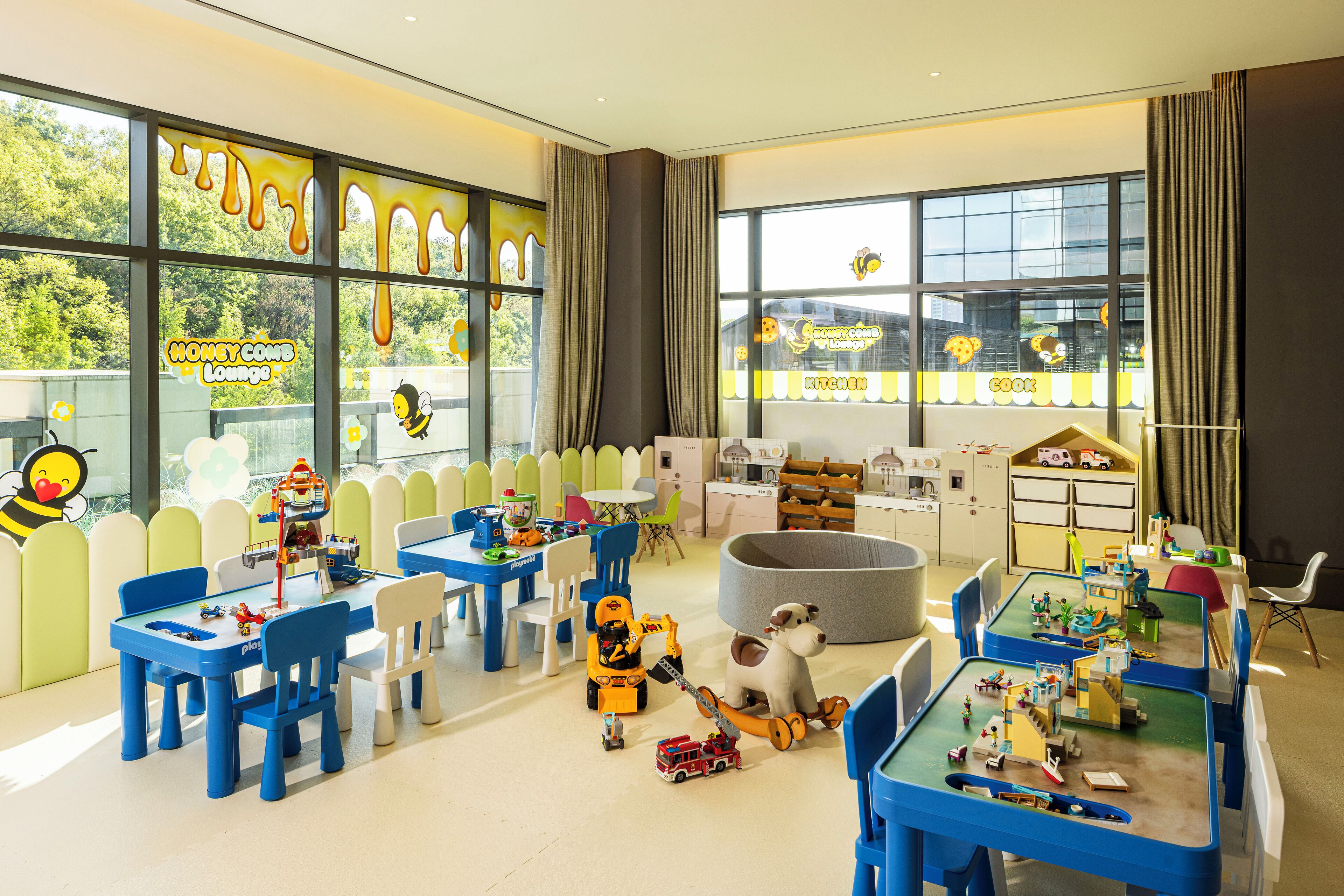 A children's play area with tables, chairs, and various toys.