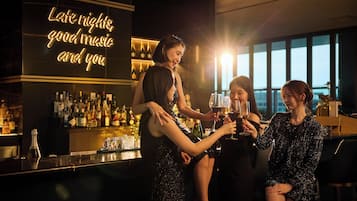 Un bar con un letrero de neón que dice: 'Noches largas, buena música y tú'.