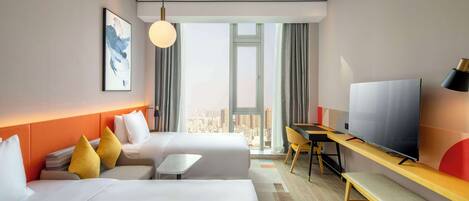 A hotel room with two beds, a desk, a TV, and a large window with a city view.
