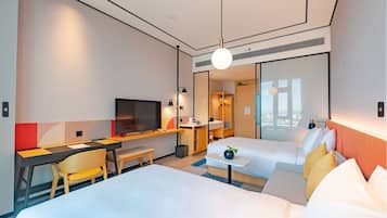 Une chambre d’hôtel avec un lit, un bureau, une télévision et une vue sur la ville.
