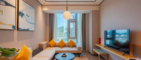 A modern living room with a sofa, a coffee table, a TV, and a large window with a city view.