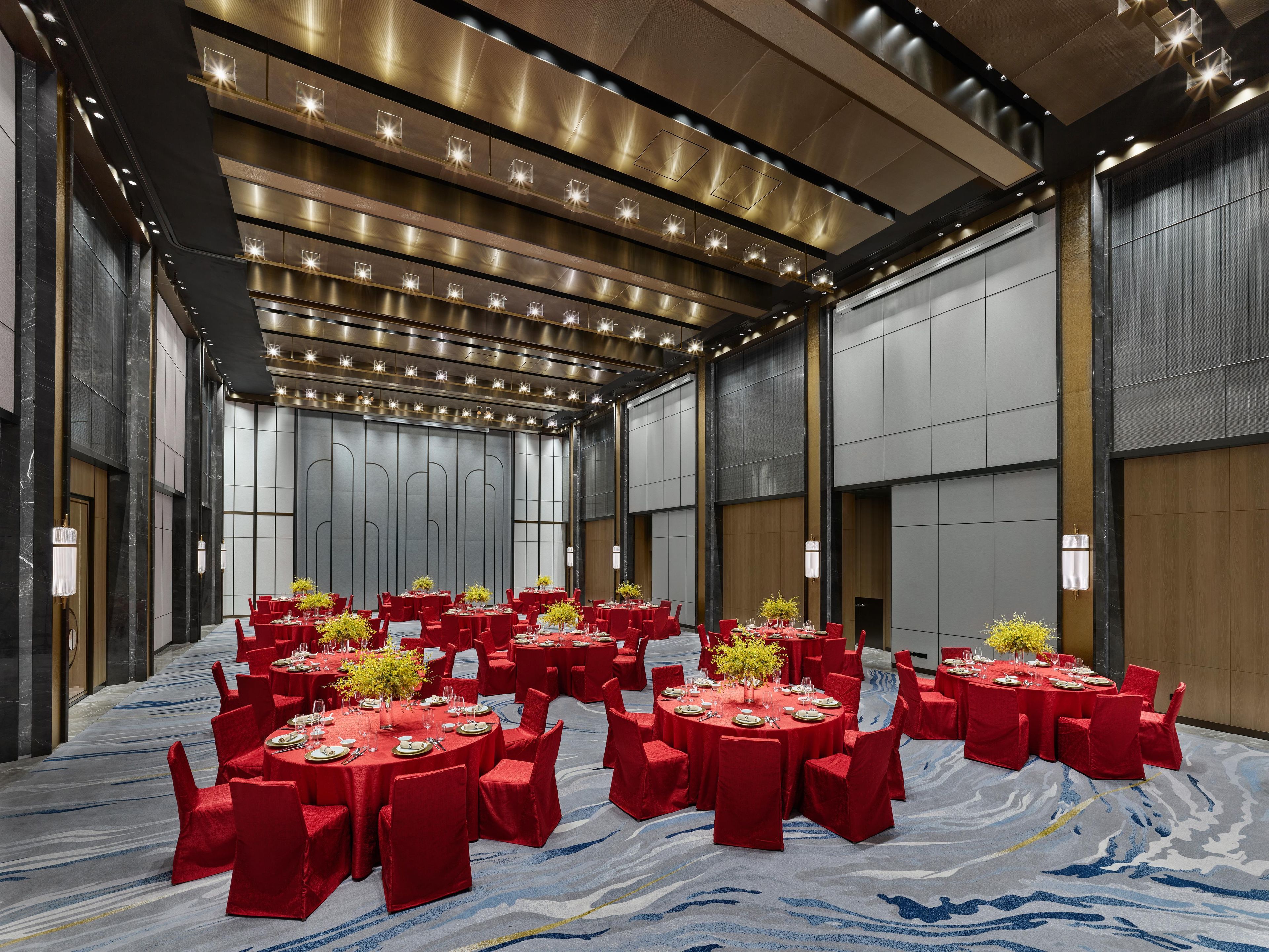A conference room with multiple tables and chairs, arranged in a semi-circular layout.