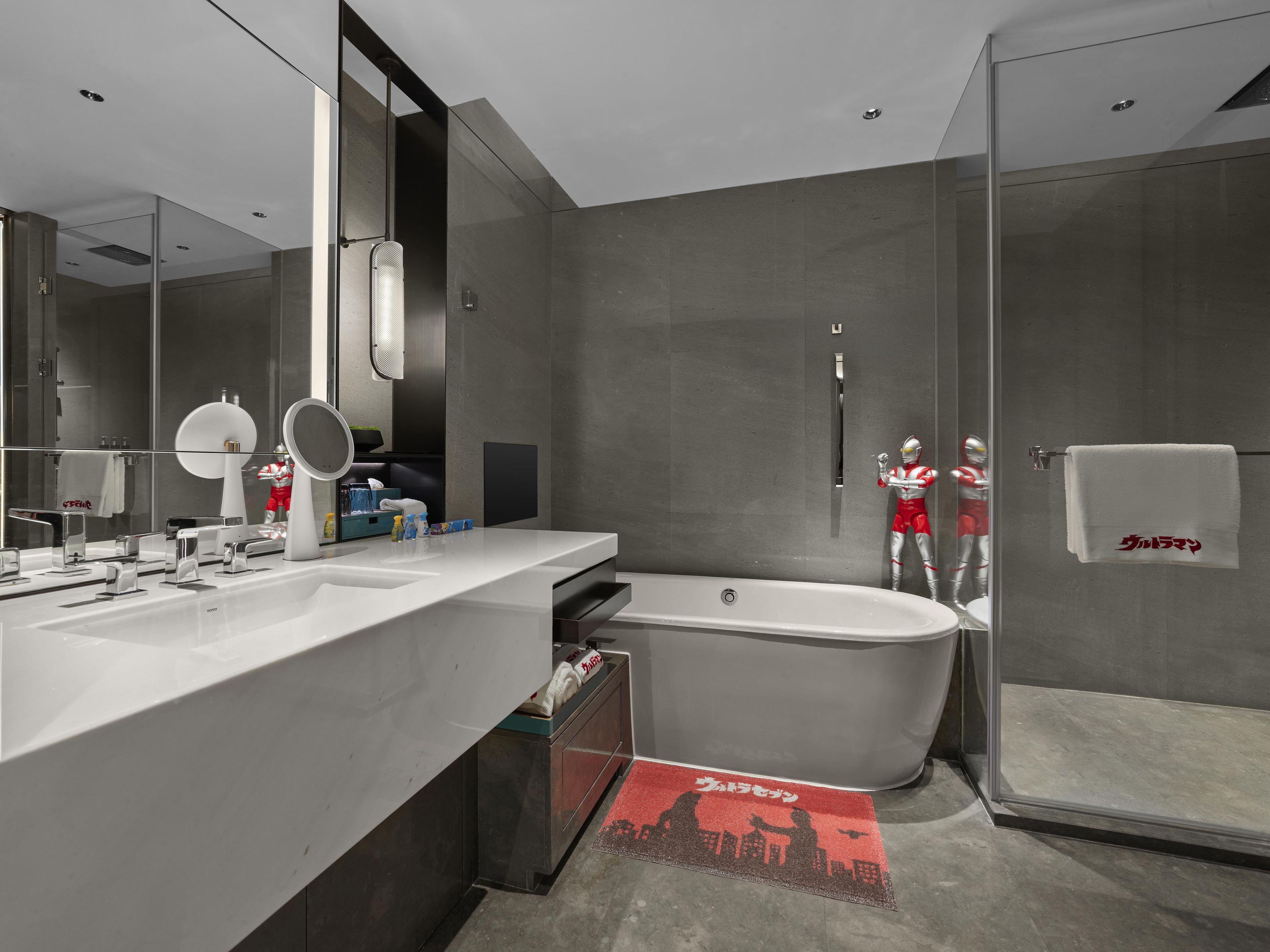 Une salle de bain moderne dotée d’une grande baignoire, d’une douche séparée et d’un meuble-lavabo avec un miroir.