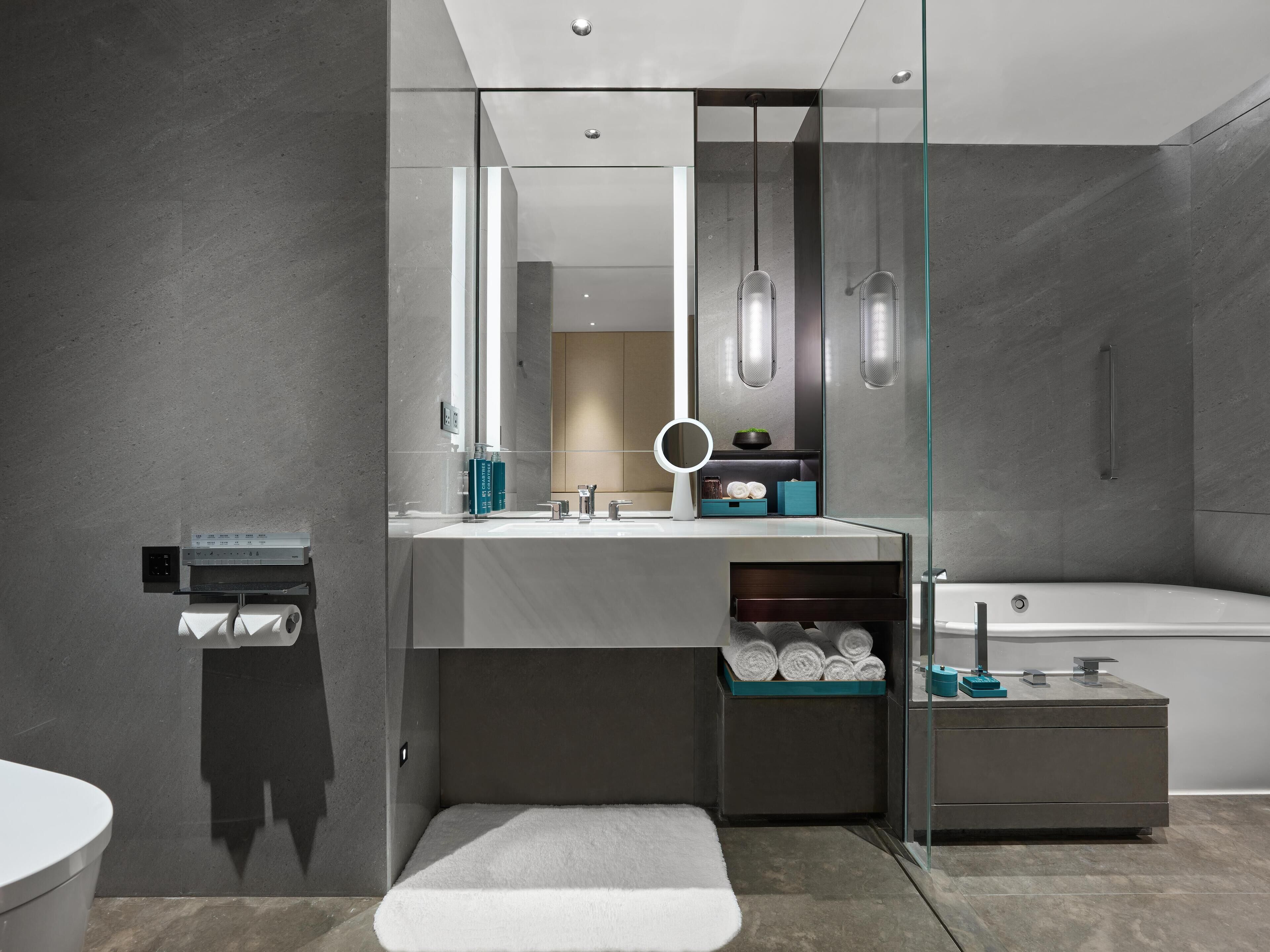 A modern bathroom with a glass-enclosed shower, a white sink, and a bathtub.
