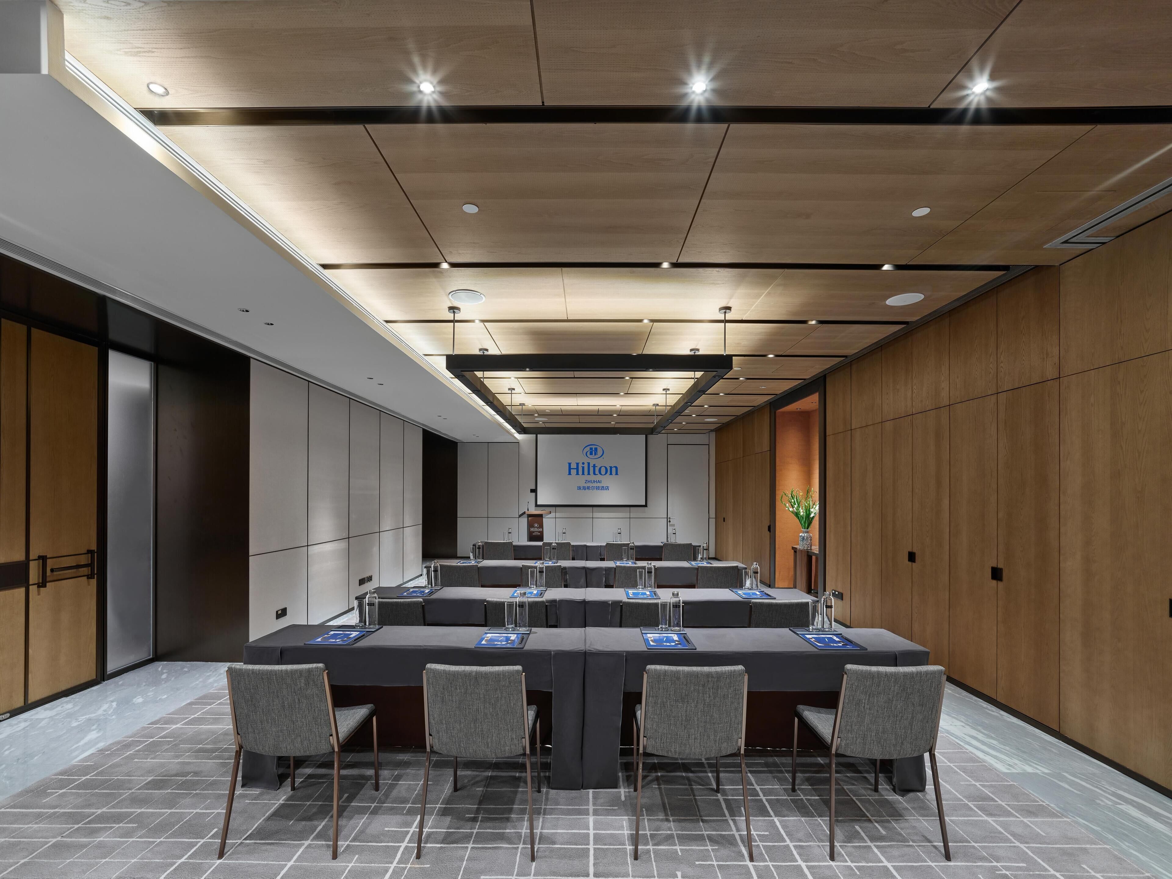 A conference room with a long table, chairs, and a podium.