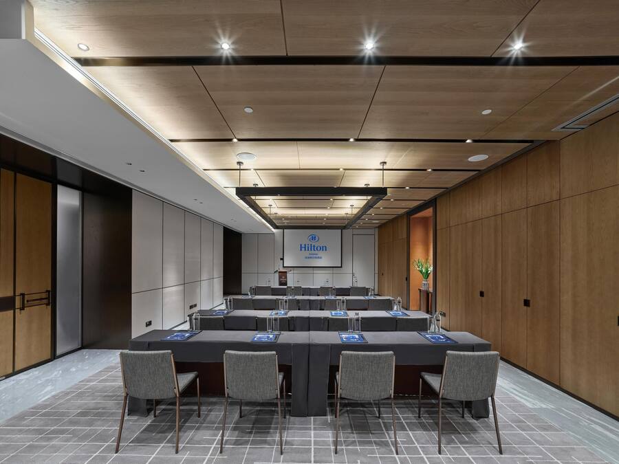 A conference room with a long table, chairs, and a podium.