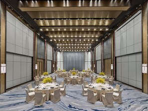 A conference room with round tables, chairs, and a modern ceiling design. - Hilton Zhuhai (Zhuhai)