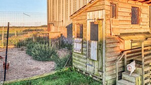 Un bâtiment rustique en bois, doté d’un petit porche et de quelques marches.