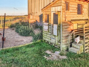 Un bâtiment rustique en bois, doté d’un petit porche et de quelques marches.