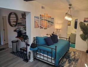 A bedroom with a bed, a coffee machine, a mirror, and artwork on the wall. - @ the Amp & Anastasia Cozy Historic Remodeled Home (St. Augustine)