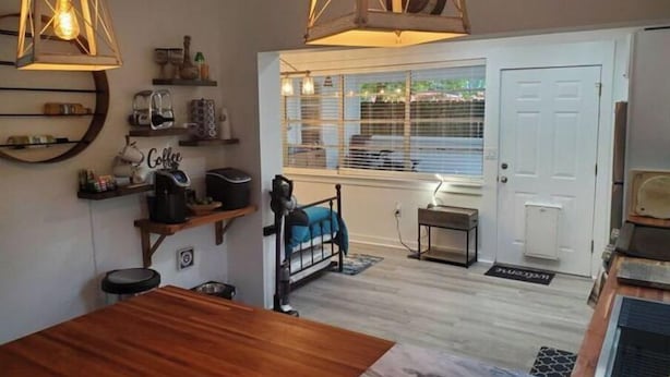 Una cocina acogedora con muebles de madera, luces colgantes y vistas al exterior.
