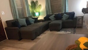 Una sala de estar moderna con un sofá modular, una mesita y una planta en maceta.