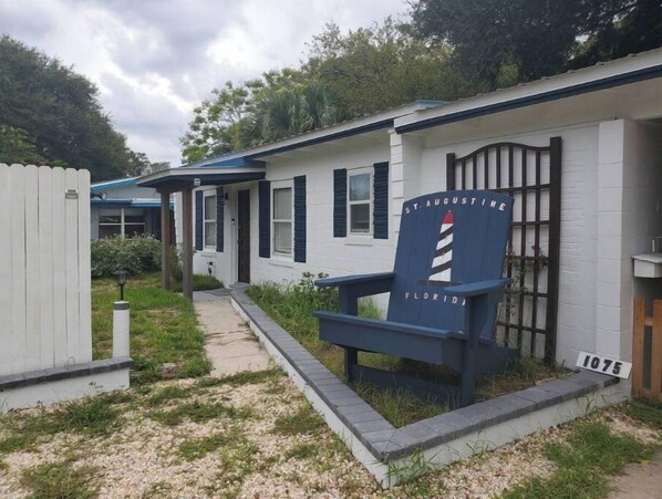 En vit byggnad med en blå stol där det står "St. Augustine, Florida" och siffran "1075" på sidan.